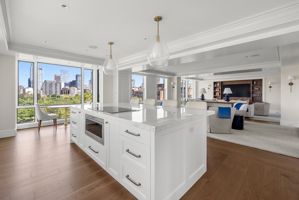 2 Commonwealth Avenue, Unit 11BCD Boston, MA 02116 - Photo 13 of 39 a large white kitchen with stainless steel appliances granite countertop a stove oven a sink dishwasher and white cabinets with wooden floor