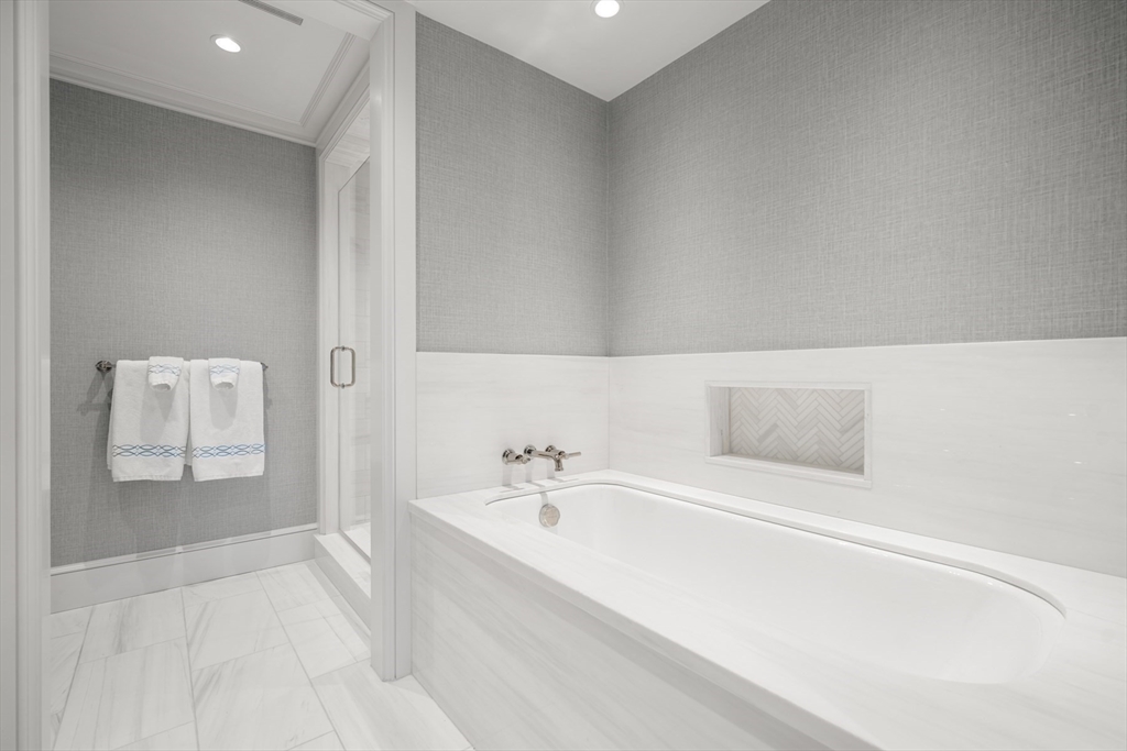2 Commonwealth Avenue, Unit 11BCD Boston, MA 02116 - Photo 33 of 39 a spacious bathroom with a bathtub and mirror