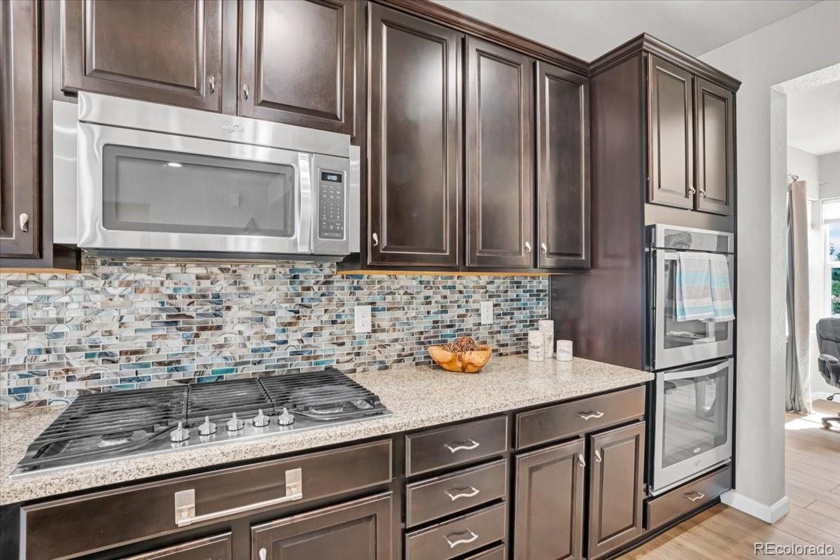 1767 Ghost Dance Circle Castle Rock, CO 80108 - Photo 12 of 48 a kitchen with stainless steel appliances a stove and a microwave