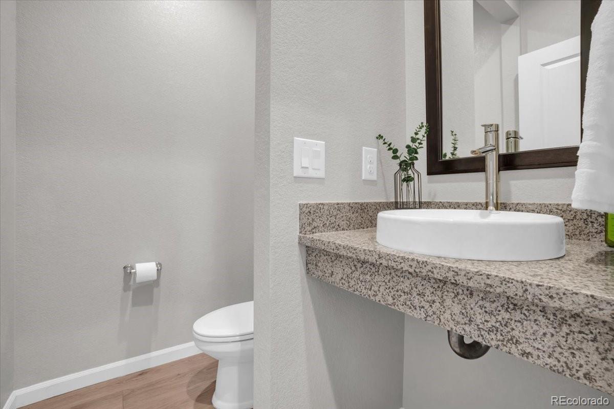 1767 Ghost Dance Circle Castle Rock, CO 80108 - Photo 17 of 48 a bathroom with a granite countertop sink and a toilet