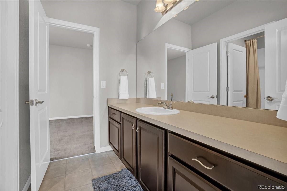 1767 Ghost Dance Circle Castle Rock, CO 80108 - Photo 27 of 48 a bathroom with a granite countertop sink and a mirror