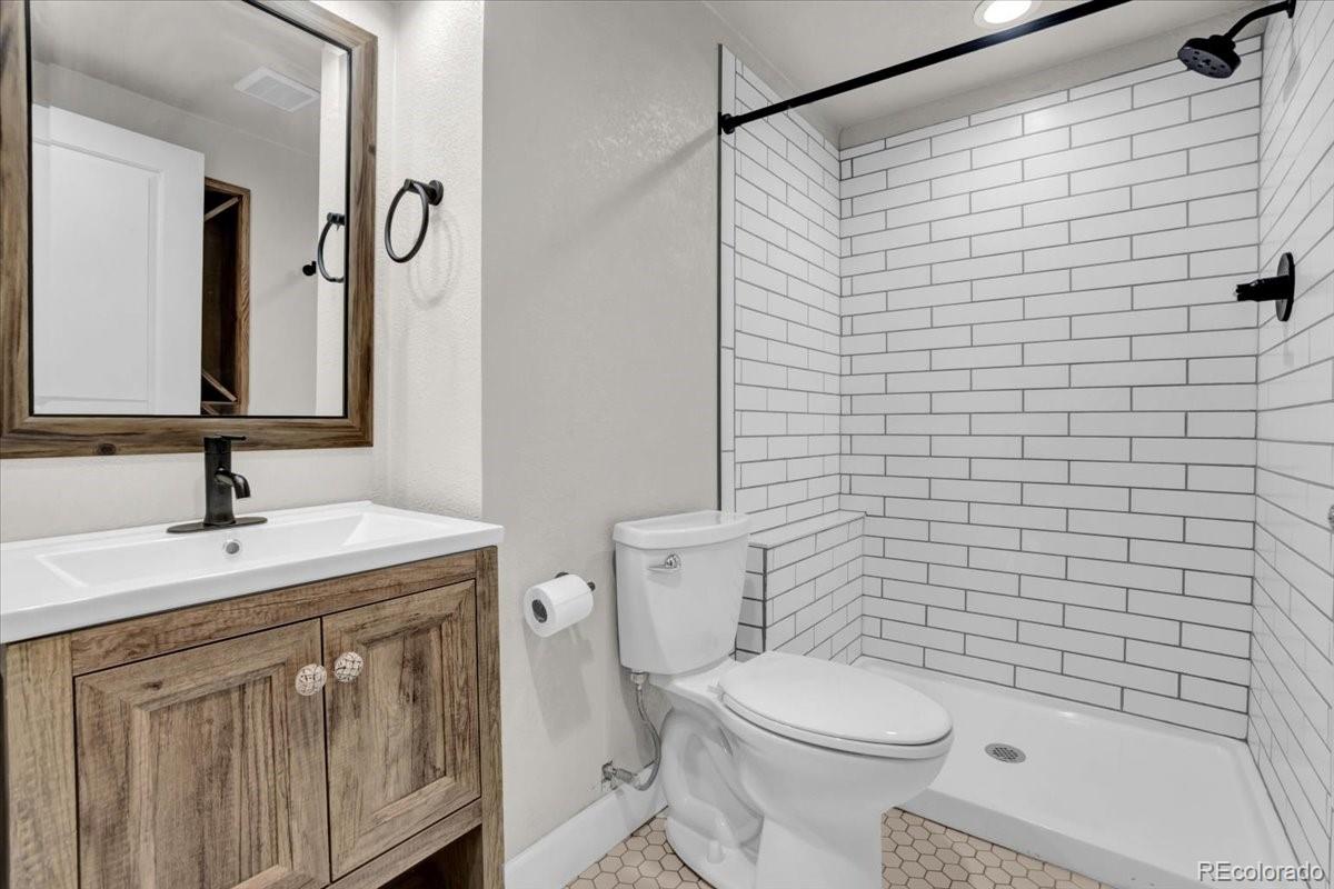 1767 Ghost Dance Circle Castle Rock, CO 80108 - Photo 35 of 48 a bathroom with a sink a toilet and shower