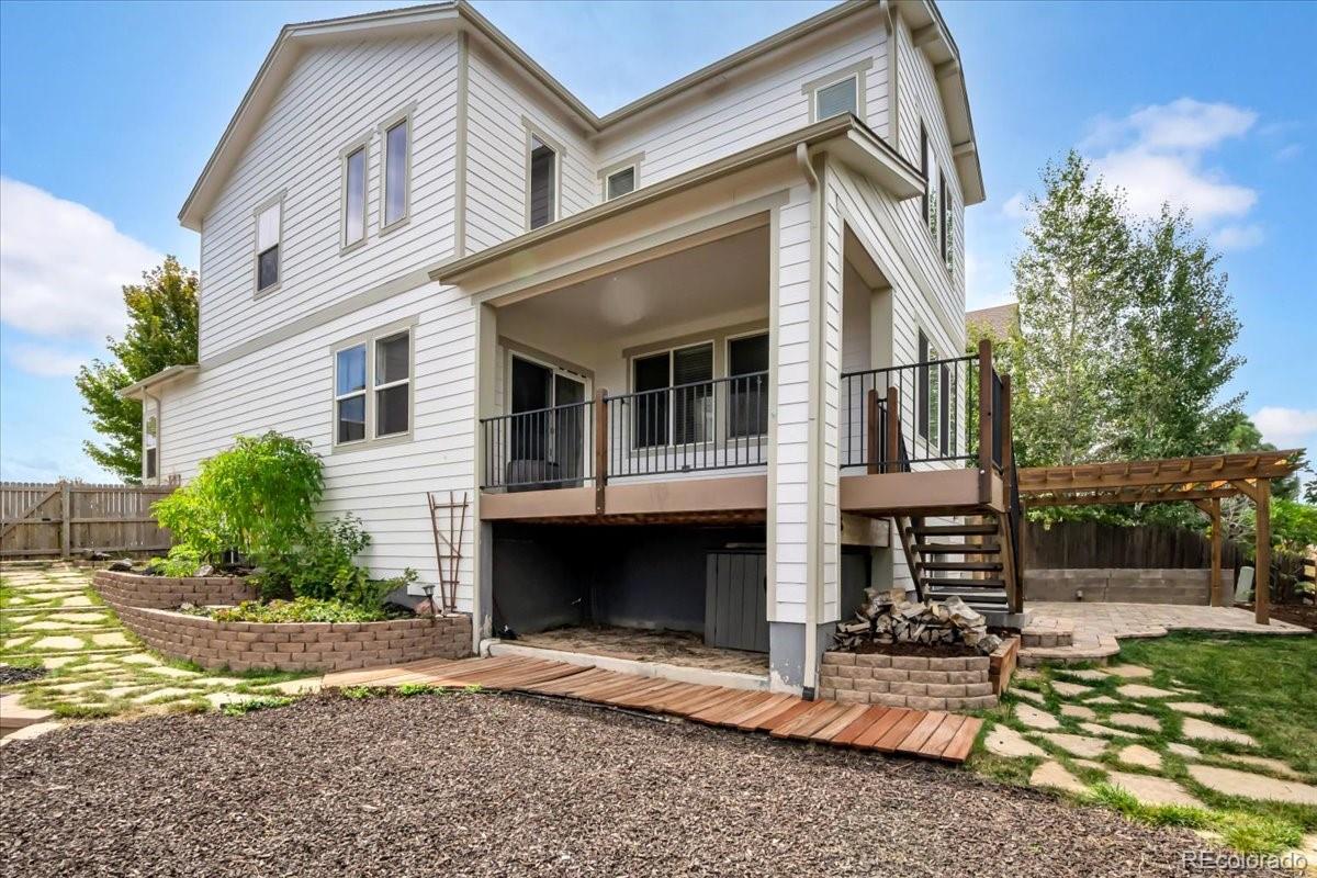 1767 Ghost Dance Circle Castle Rock, CO 80108 - Photo 4 of 48 a view of a white house with large windows and a small yard