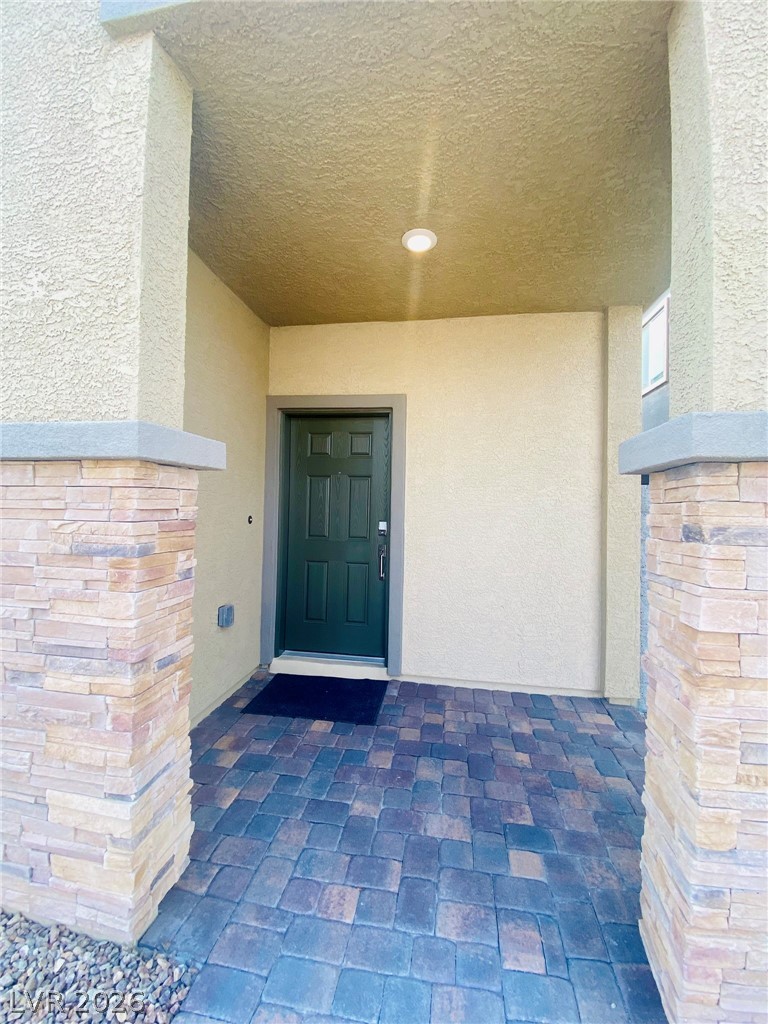 4457 Sawyer Ridge Street Las Vegas, NV 89147 - Photo 30 of 32 Enter this charming residence through a welcoming porch with durable paver flooring and elegant stone columns.