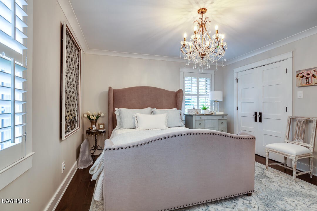 433 Smith Road Knoxville, TN 37934 - Photo 23 of 42 a spacious bedroom with a bed and a chandelier