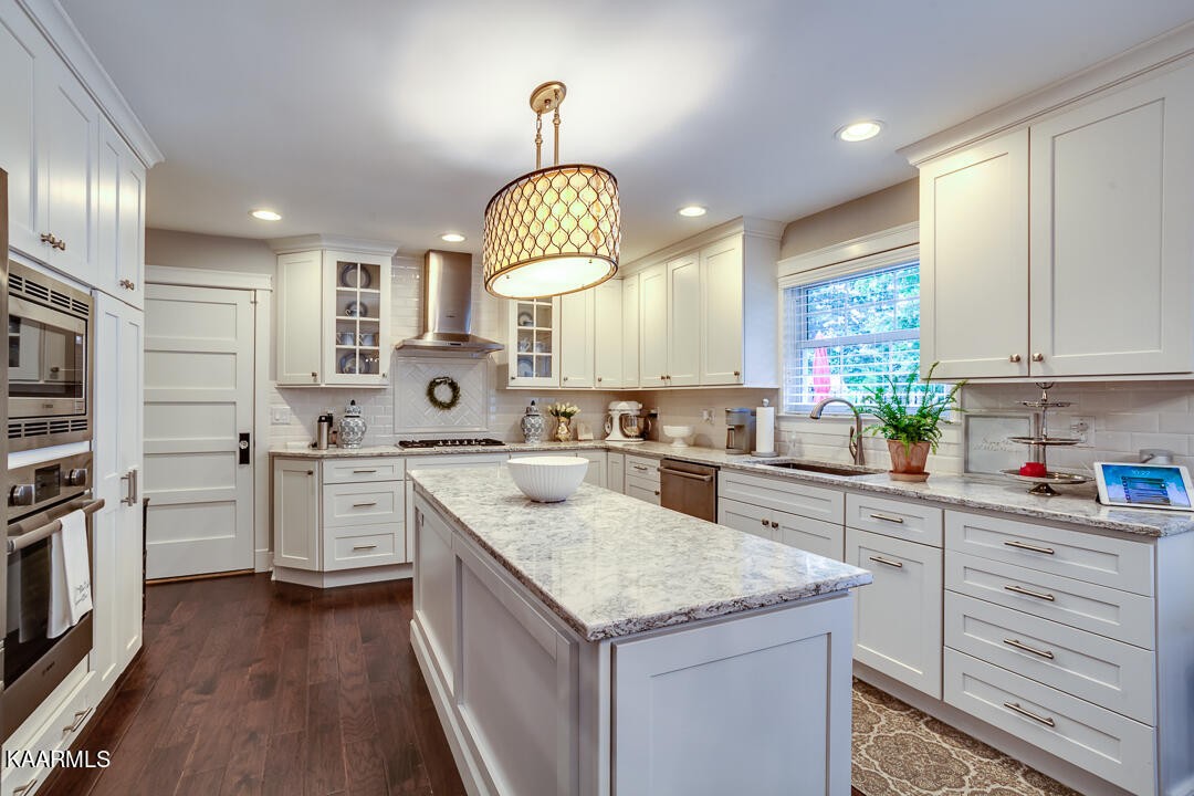 433 Smith Road Knoxville, TN 37934 - Photo 8 of 42 a kitchen with stainless steel appliances granite countertop a stove a sink dishwasher and white cabinets with wooden floor