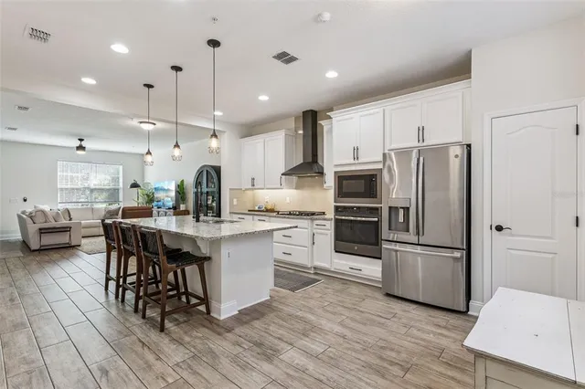 a kitchen with a stove and a wooden floor