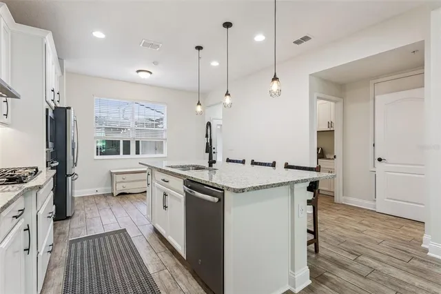 a kitchen with stainless steel appliances a refrigerator and a stove top oven