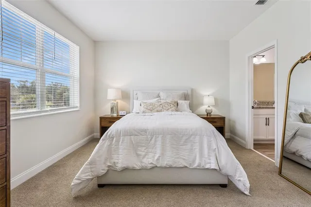 a view of a hallway with wooden floor and a bathroom