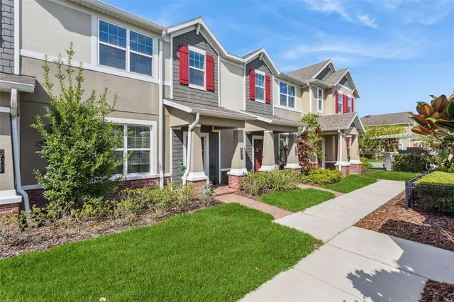a front view of a house with a yard and potted plants