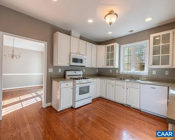a kitchen with granite countertop white cabinets and white appliances
