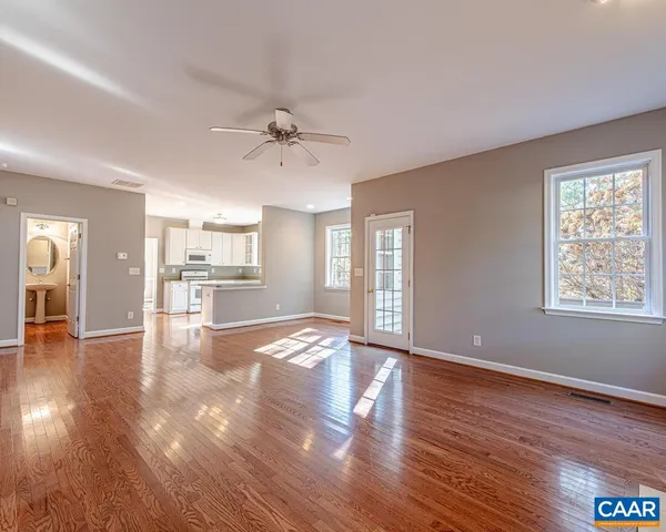 a view of empty room with wooden floor and window
