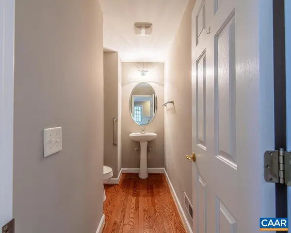 a view of a hallway with wooden floor windows