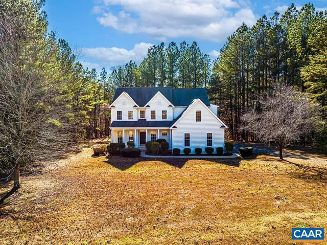 a front view of a house with a yard covered with snow