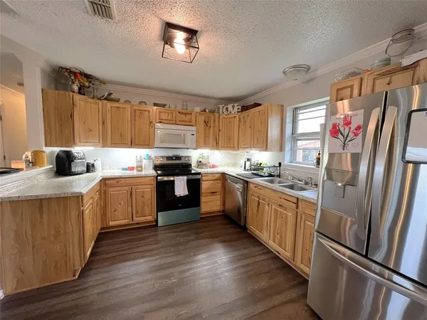 a kitchen with granite countertop stainless steel appliances a refrigerator sink and microwave