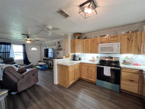a kitchen with stove and wooden floor