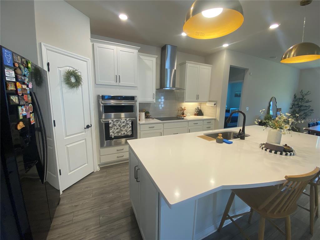 9610 Rally Spring Loop Wesley Chapel, FL 33545 - Photo 8 of 38 a large kitchen with a table chairs and a refrigerator