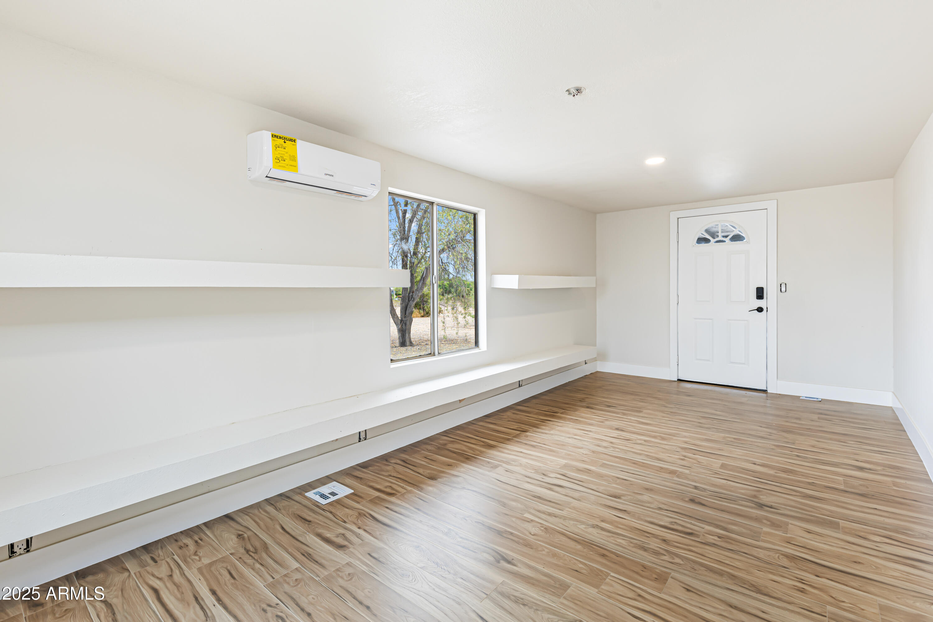 34040 West Lower Buckeye Road Tonopah, AZ 85354 - Photo 19 of 45 a view of an empty room with a window and wooden floor