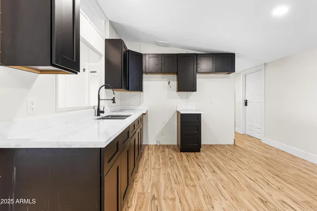 a kitchen with stainless steel appliances granite countertop a sink and a refrigerator