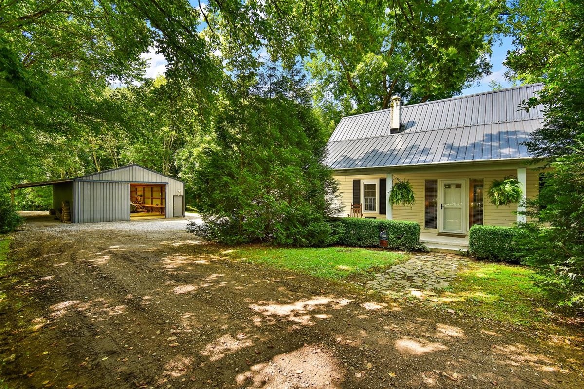a front view of a house with a garden and trees