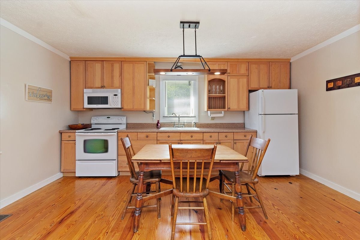 1570 Wolf Creek Road Silver Point, TN 38582 - Photo 10 of 40 a kitchen with granite countertop wooden floors and white appliances