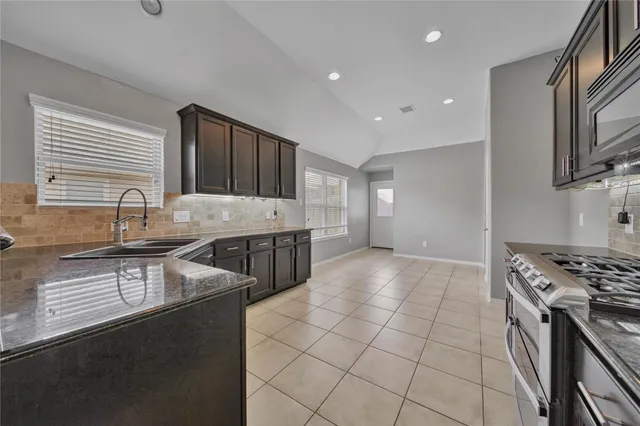 a kitchen with stainless steel appliances granite countertop a sink stove and cabinets
