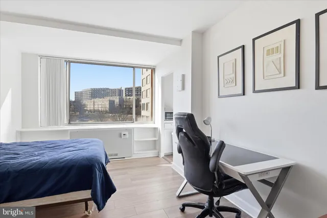 a view of a workspace with furniture and a window