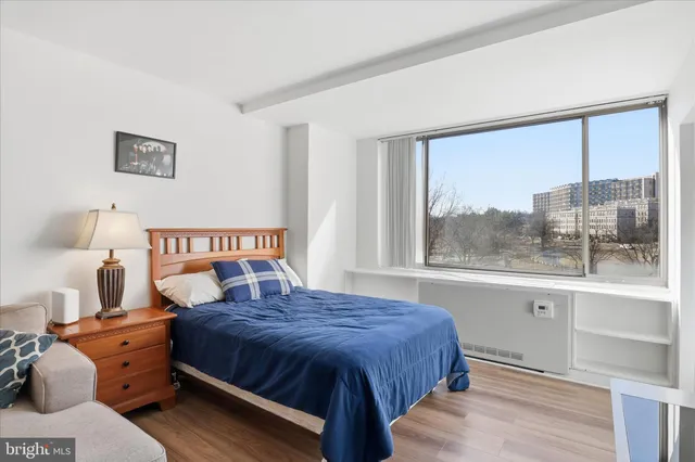 a bedroom with a bed and a large window
