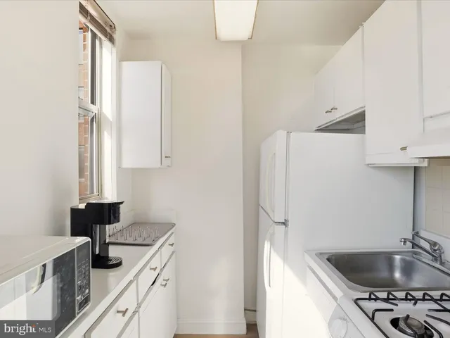 a kitchen with white cabinets and a sink