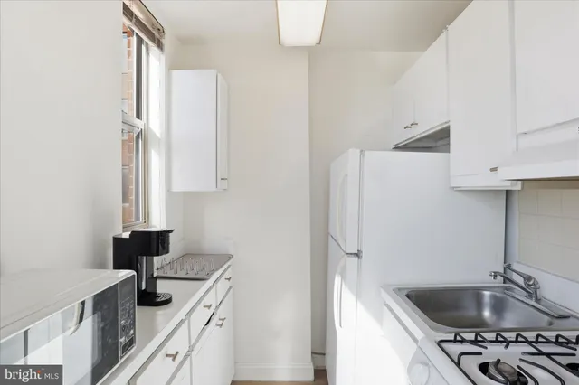 a kitchen with stainless steel appliances granite countertop a sink and a refrigerator