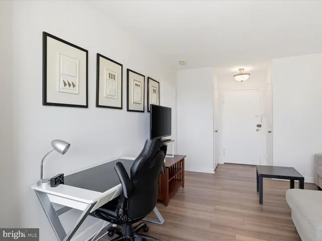 a view of a workspace with furniture and wooden floor