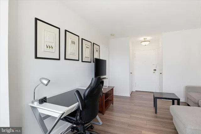 a view of a workspace with furniture and wooden floor