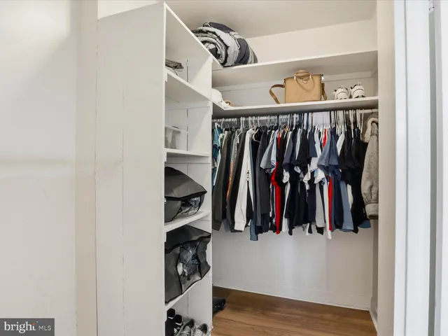 a view of walk in closet with clothes and shoes