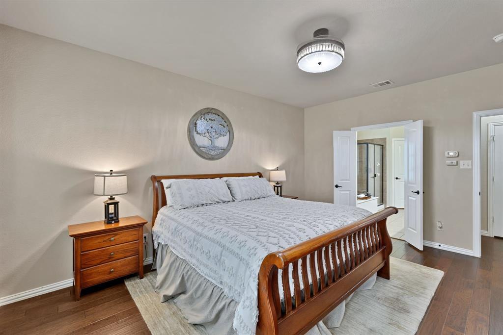1701 Meadow Ranch Road McKinney, TX 75071 - Photo 18 of 40 a bedroom with a bed and a chandelier