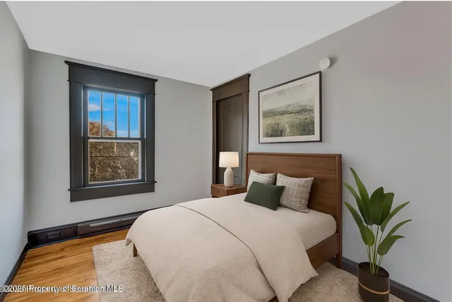 a bedroom with a large bed and a potted plant