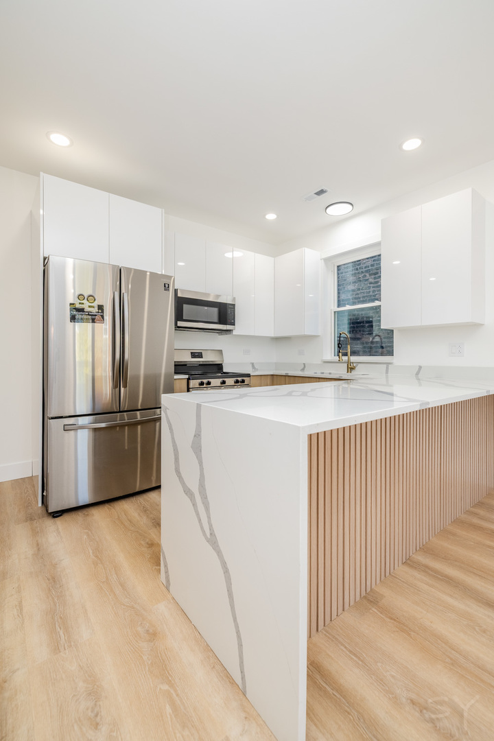 2949 West 25th Place, Unit 1 Chicago, IL 60623 - Photo 11 of 42 a kitchen with stainless steel appliances granite countertop a refrigerator and a stove top oven