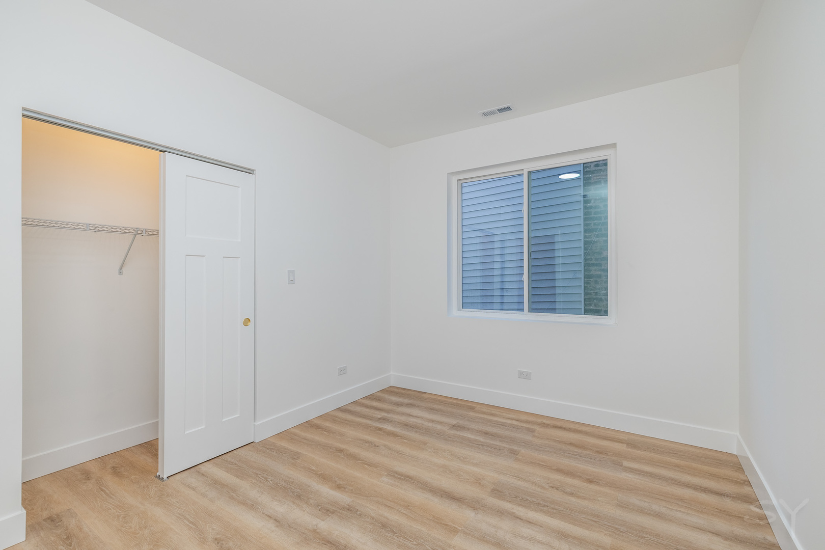 2949 West 25th Place, Unit 1 Chicago, IL 60623 - Photo 18 of 42 a view of an empty room with wooden floor and a window