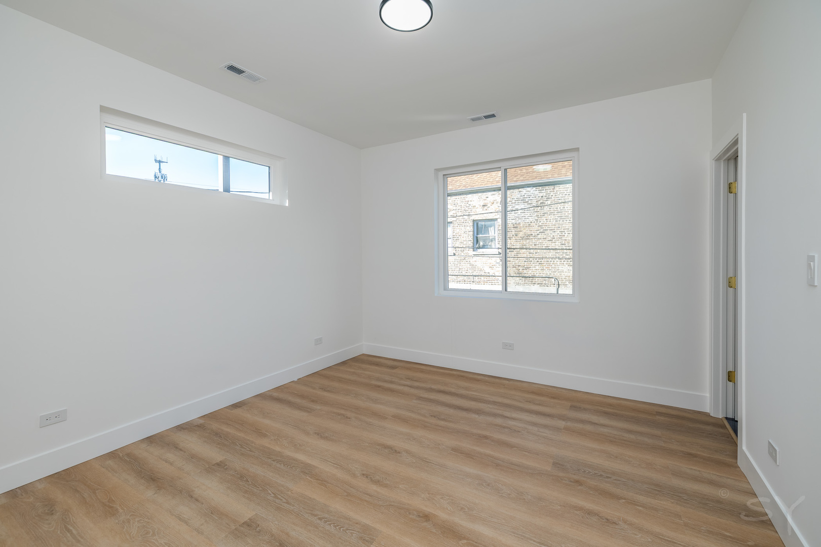 2949 West 25th Place, Unit 1 Chicago, IL 60623 - Photo 32 of 42 an empty room with wooden floor and windows