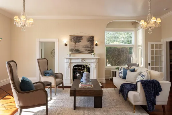 a living room with furniture a chandelier and a fireplace