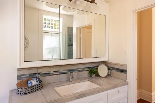 a bathroom with a granite countertop sink and a mirror