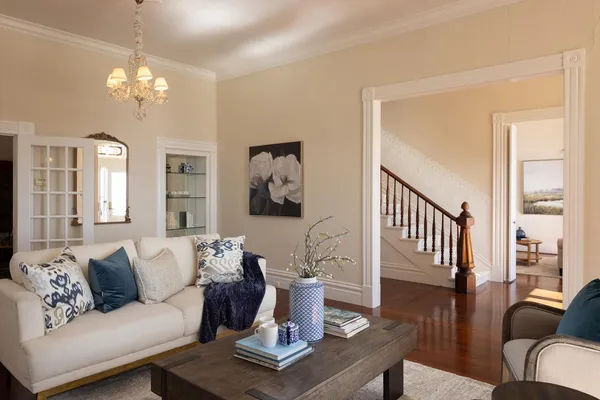a living room with furniture a lamp wooden floor and a chandelier