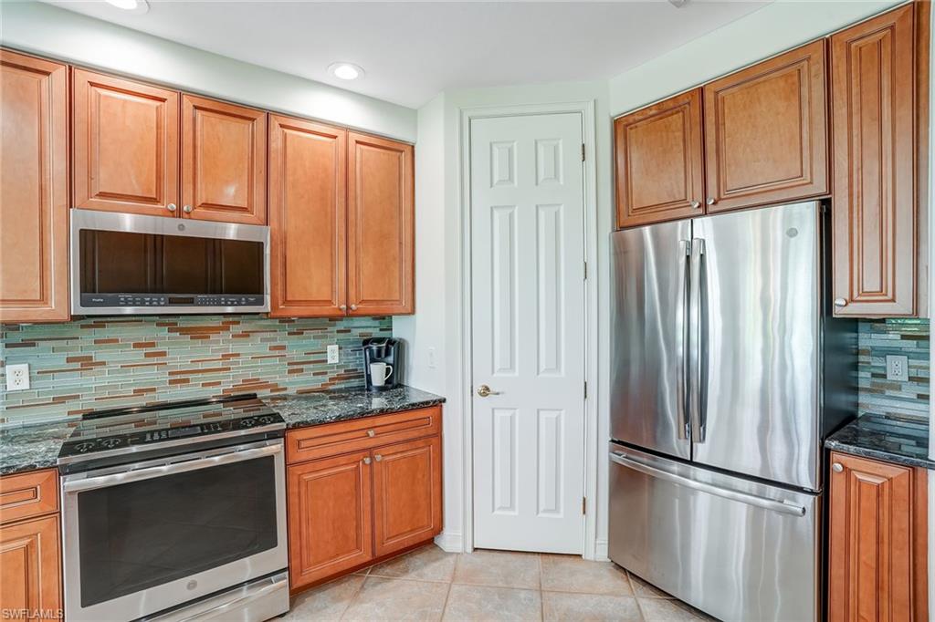 9350 Triana Terrace, Unit 292 Fort Myers, FL 33912 - Photo 12 of 28 a kitchen with stainless steel appliances granite countertop a refrigerator stove and microwave