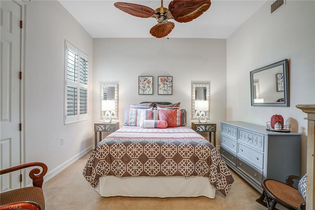 9350 Triana Terrace, Unit 292 Fort Myers, FL 33912 - Photo 20 of 28 a bedroom with a large bed and a chandelier