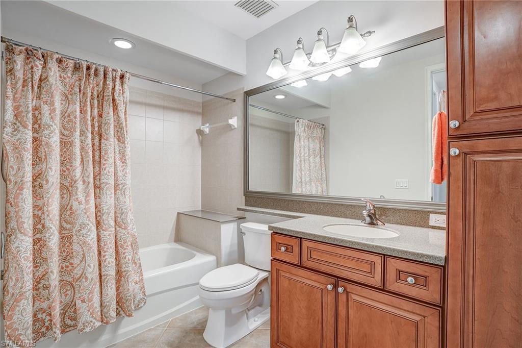 9350 Triana Terrace, Unit 292 Fort Myers, FL 33912 - Photo 22 of 28 a bathroom with a toilet a sink and a large mirror