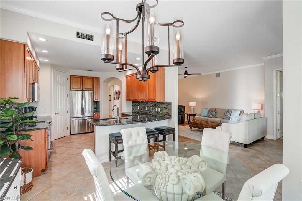 9350 Triana Terrace, Unit 292 Fort Myers, FL 33912 - Photo 8 of 28 a living room with furniture and a chandelier