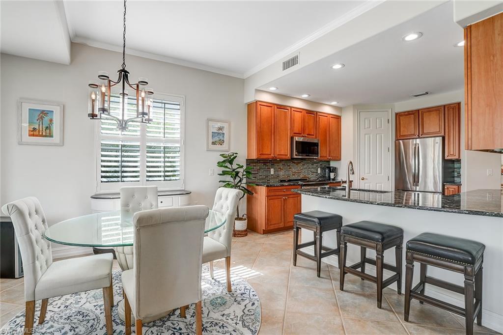 9350 Triana Terrace, Unit 292 Fort Myers, FL 33912 - Photo 9 of 28 a dining room with furniture a window and stainless steel appliances