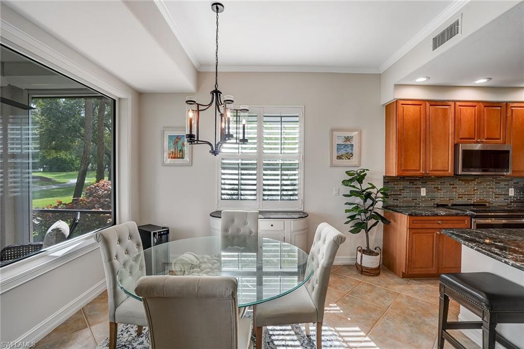 9350 Triana Terrace, Unit 292 Fort Myers, FL 33912 - Photo 10 of 28 a kitchen with stainless steel appliances granite countertop a stove a sink a table and chairs