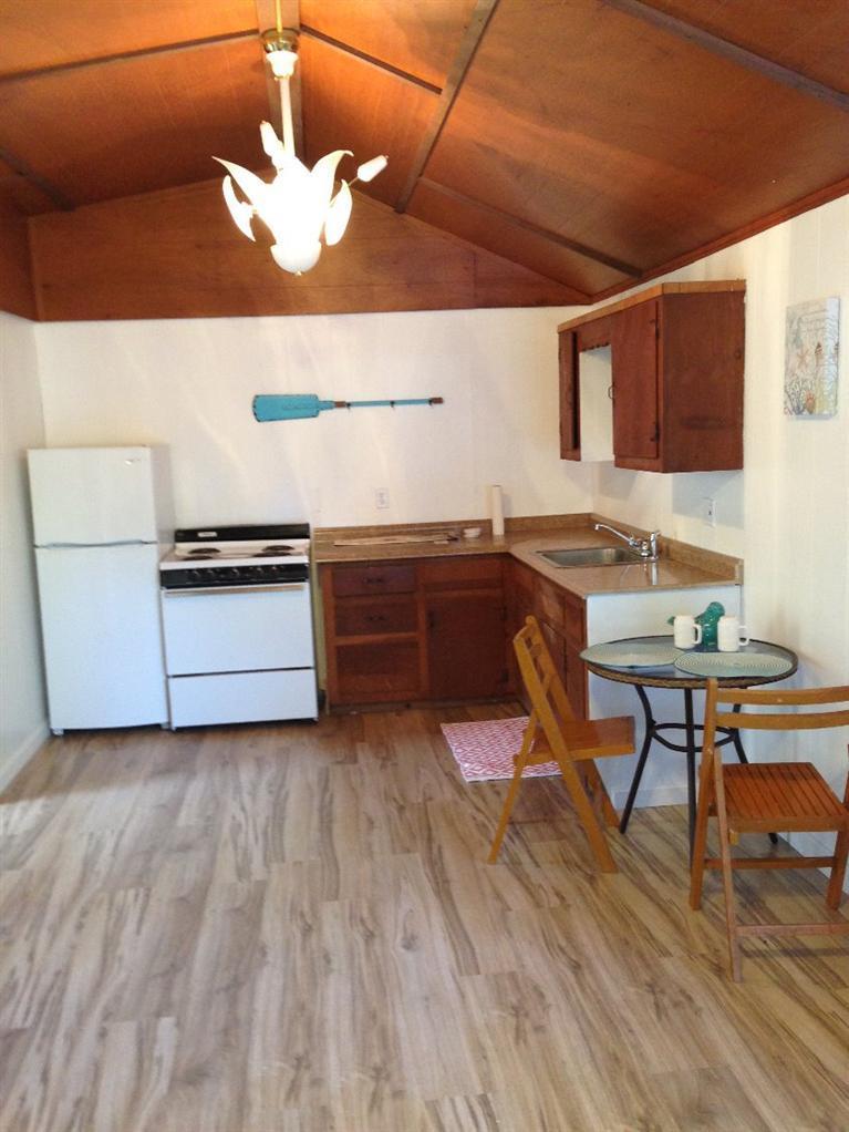 73 Shad Hole Road, Unit 3 Dennis Port, MA 02639 - Photo 4 of 15 a kitchen with stainless steel appliances granite countertop a sink dishwasher a stove a refrigerator with island and chairs