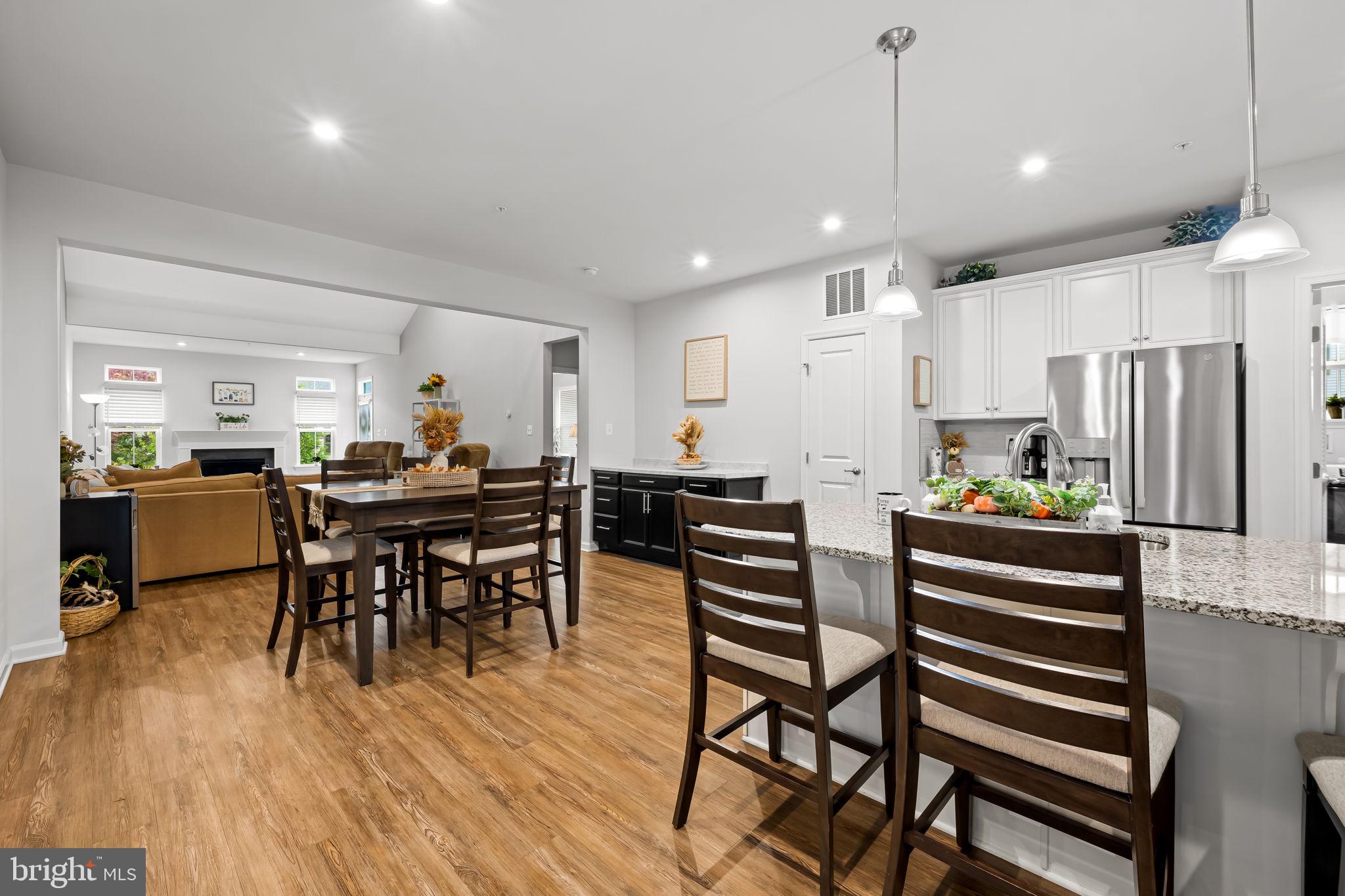 7728 Pestle Lane Glen Burnie, MD 21060 - Photo 12 of 66 a kitchen with stainless steel appliances kitchen island granite countertop a table chairs and a refrigerator