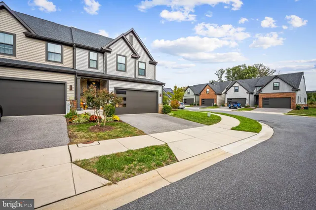 a kitchen with stainless steel appliances granite countertop a stove a sink a dining table and chairs with wooden floor